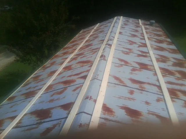 Rusted metal roof panels with new wood purlins before replacement — Storm Damage Roof Repair in New Iberia by Roofing Brothers