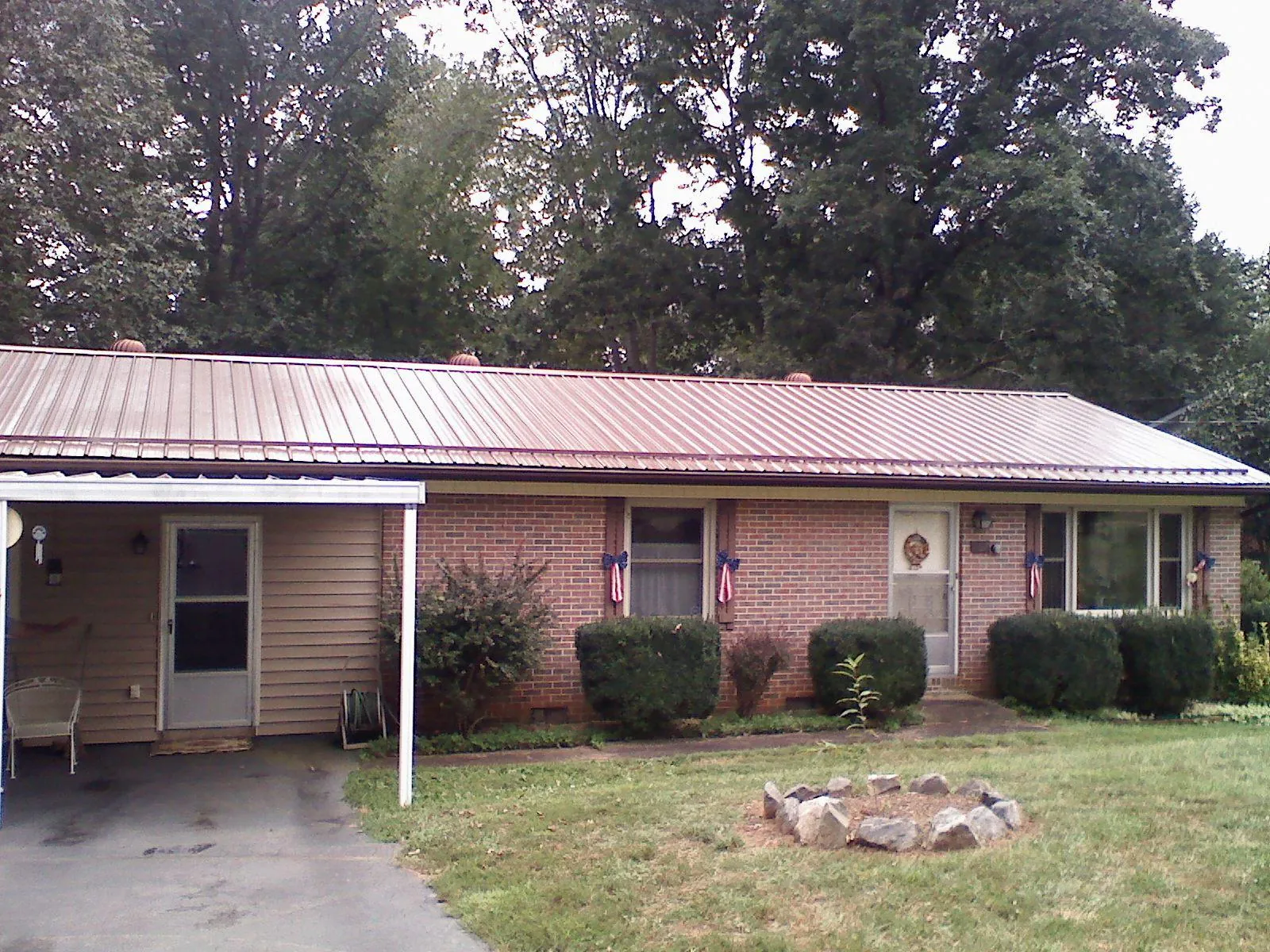 Bronze metal roof and carport on a brick ranch home — Roof Repair work by our crew in New Iberia