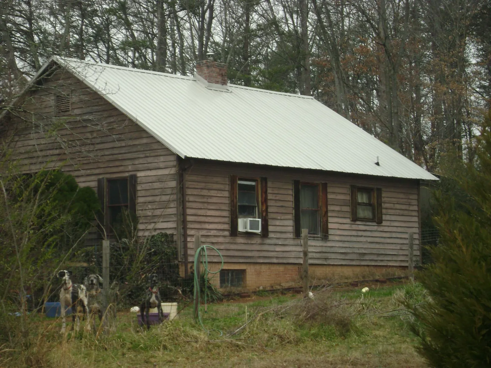 White metal roof on an old wood sided farmhouse, from a Metal Roof Installation job in New Iberia